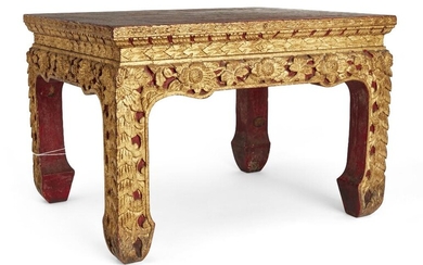 A Thai carved giltwood small table, 19th century, carved to the sides and legs with flowering lotus scrolls, 41cm wide, 28cm high 泰國十九世紀 木雕漆金矮桌