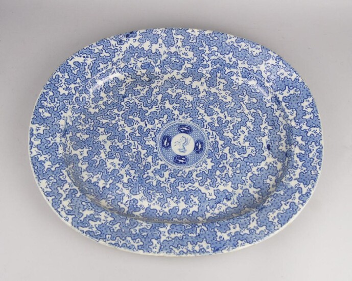 A Victorian blue and white ironstone meat plate, applied to the centre with a circular armorial of a winged unicorn, the main body printed with vermicule patterning, 54 x 46cm