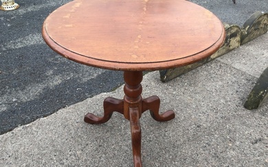 A Victorian mahogany tea table with circular moulded top tilting...