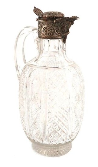 A Victorian silver-mounted cut glass claret jug, by Brockwell & Son, London 1885, ovoid form, the hob-nail cut decoration, scroll handle, the mount with foliate scroll decoration and with a Bacchus mask, domed hinged cover with a pierced thumb-piece...