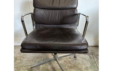 A Vitra Eames soft pad chair with brown leather and chrome o...