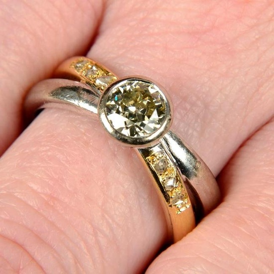 A circular-cut diamond single-stone ring, with rose-cut diamond accent bi-colour crossover