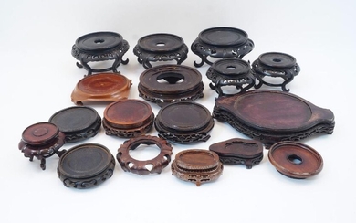 A collection of Chinese carved and pierced hardwood stands, 20th century, to include five circular examples raised on scrolling S-shape feet, three 14cm diameter, two 9cm diameter, and various others including some fitted examples, sixteen in total...
