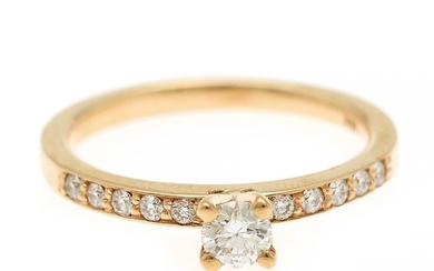 A diamond ring set with a diamond weighing app. 0.21 ct. flanked by ten diamonds, totalling app. 0.13 ct., mounted in 18k gold. Size 53.