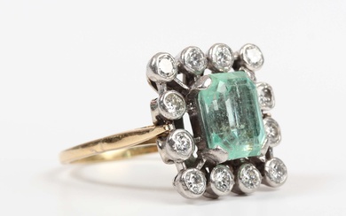 A gold and platinum, emerald and diamond cluster ring, claw set with the cut cornered rectangular st