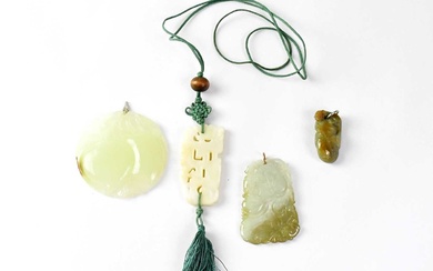 A green jade circular pendant carved with a pair of...