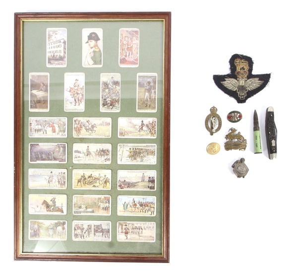A group of militaria collectables. Including a Royal Berkshire cap badge, Royal Corps of Signals, a penknife, framed John Player cigarette cards depicting Napoleon, etc