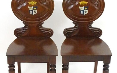 A pair of 19thC mahogany hall chairs shaped, carved