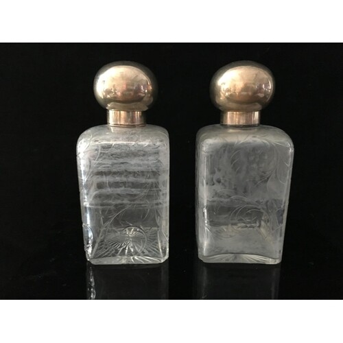 A pair of cut glass and French white metal perfume flasks, o...