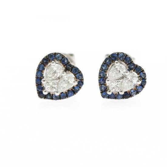 A pair of heart shaped sapphire and diamond ear studs each set with numerous circular-cut sapphires and three diamonds, mounted in 18k white gold. (3)