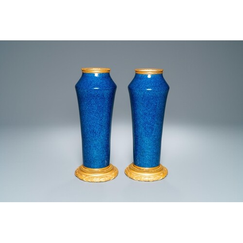 A pair of monochome powder blue Sèvres vases with gilded bro...