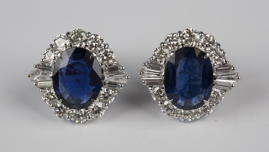 A pair of white gold, sapphire and diamond cluster earrings, each claw set with an oval cut sapphire