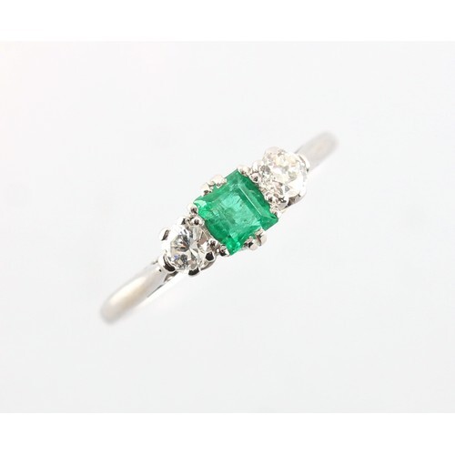 A platinum emerald & diamond three stone ring, the vibrant g...