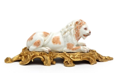 A porcelain lion mounted on a brass base