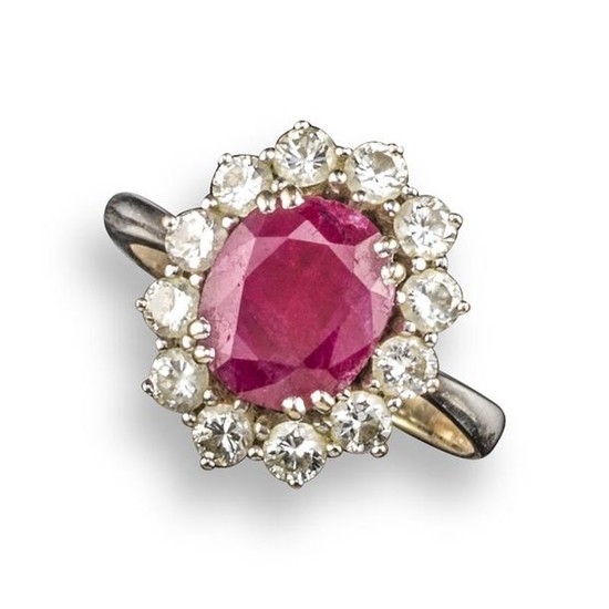 A ruby and diamond cluster ring, the oval-shaped...