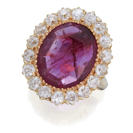 A ruby and diamond ring centering an oval-cut ruby...