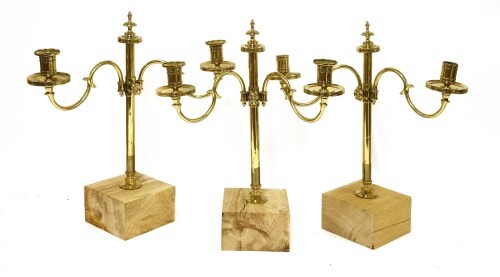 A suite of three late Regency brass two-light candleholders
