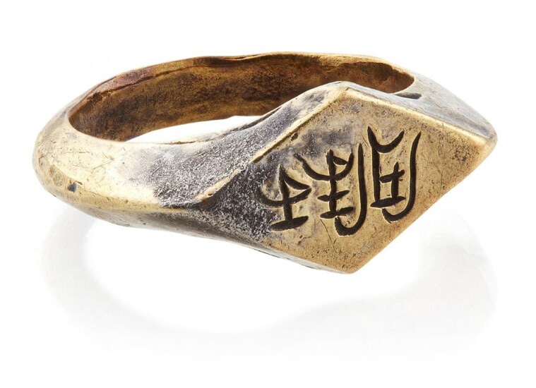 A very rare white HuN Swat valley gold ring with inscription "Sri Khalq", Pakistan, 9th-10th century, cast, with flat bezel and well-defined central rib to band, the bezel engraved and filled with black substance allowing the incised inscription to...