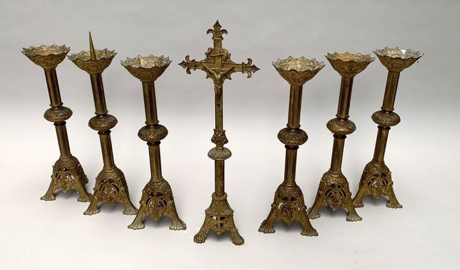 AUTEL GARNITURE in chiselled bronze and formerly gilded in neo-Romanesque style, with stylised foliage decoration. It includes six carved steel picks and an altar cross of an approximate model. The height of the pickets is 56 cm. Height of the cross...