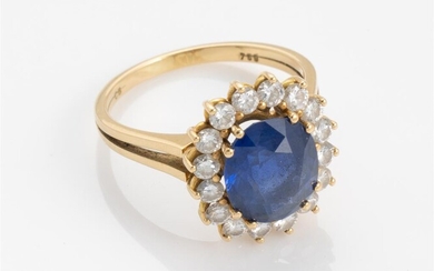 An 18ct gold halo ring set with oval cut ceylon...