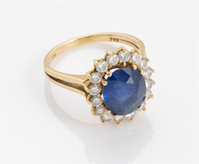 An 18ct gold halo ring set with oval cut ceylon...
