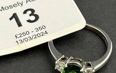 An 18ct white gold dress ring, set a green tourmaline, and t...