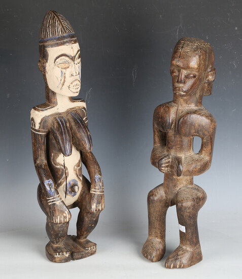 An African carved and painted wooden ancestor figure, height 57cm, together with another carved wood