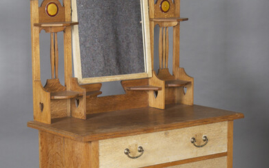 An Edwardian Arts and Crafts oak dressing chest by Shapland & Petter of Barnstaple, the swing mi
