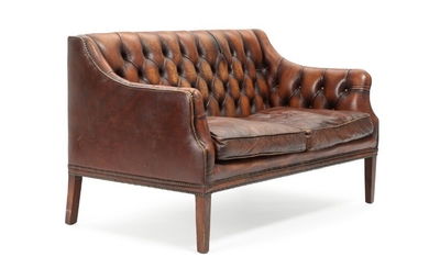 An English two-seater sofa, upholstered with brown leather fitted with nails, mahogany legs. George III style. Circa 1900. L. 135 cm.