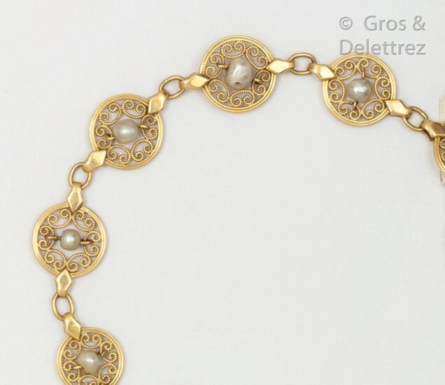 Articulated yellow gold bracelet with round filigree links, each set with a cultured pearl. Length: 19.5cm. Gross weight: 14.2g.