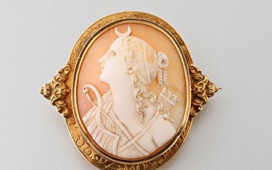 Napoleon III brooch in 750 thousandths yellow gold, the chiselled rim decorated with foliage, the sides decorated with applied winding motifs, it is set with a shell cameo with the effigy of Diane Chasseresse Gross