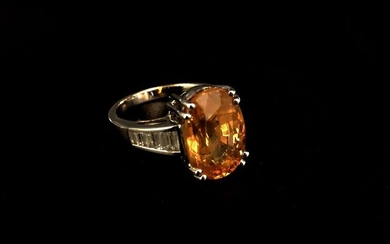 RING in white gold set with an oval-cut yellow sapphire...