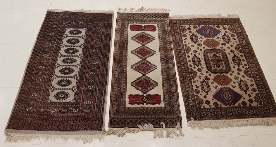 THREE RUGS knotted hands, dominant beige, with geometric decoration one...