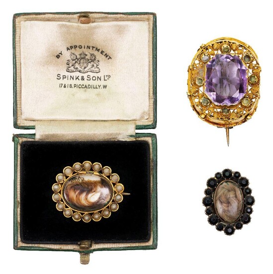 Three brooches, comprising: a gold and amethyst brooch, c.1830, centring on a cut-cornered rectangular mixed-cut amethyst within a gold cannetillle surround; a gold and seed pearl mourning brooch, centring on an oval glazed locket containing a lock...