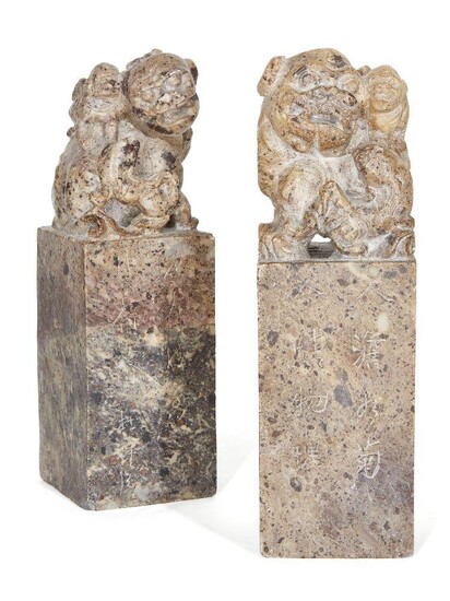 Two Chinese soapstone seals, early 20th century, carved as foo dogs perched atop rectangular columns, the sides inscribed, 17.5cm high (2)