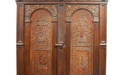 An 18th century and later oak housekeeper's cupboard extensively carved throughout with foliate and floral designs, with...
