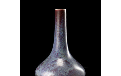 A flambè-glazed bottle vase, of squat form, of a vibrant purple tone (restorations) China, 18th century (h.21 cm.)