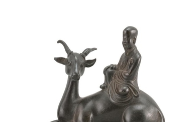 CHINESE BRONZE SCROLL WEIGHT In the form of a sage seated on a stag. Black-brown patina. Height 4". Length 5".