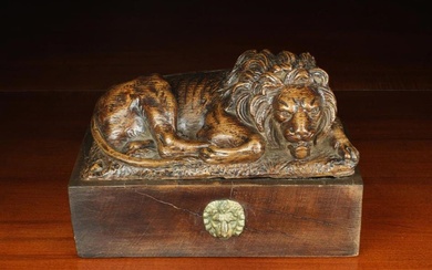 A 19th Century Carved Oak 'Canova' Lion. The recumbent beast mounted on a rectangular mahogany bloc