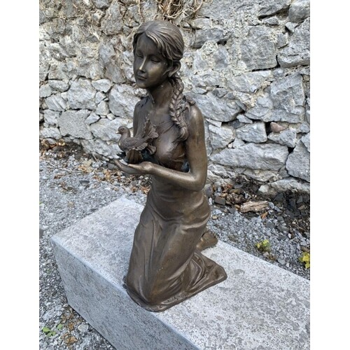 A BRONZE GARDEN FIGURE, in the form of a kneeling woman hold...