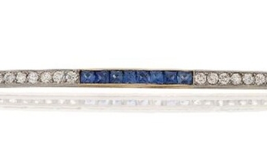 A Belle Epoque, diamond, gold, platinum and sapphire brooch, the slightly curved gold bar alternately set with two sections of nine brilliant-cut diamonds with three sections of French calibre-cut diamonds, with rose-cut diamond and seed pearl...