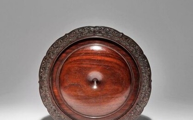 A CHINESE HARDWOOD CIRCULAR STAND 18TH CENTURY Carved with a...