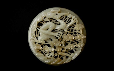 A CHINESE RETICULATED WHITE AND RUSSET JADE 'DRAGON' ROUND PLAQUE 十九世紀 白玉糖色龍趕珠紋珮