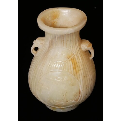 A CHINESE WHITE JADE BALUSTER VASE With mask handles and car...