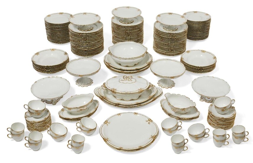 A Limoges porcelain (Theodore Haviland) part dinner service, 20th century, with gilt decoration, comprising; twelve coffee cups and eleven saucers, twelve teacups and eleven saucers, two sauce boats with fixed stands, two large oval dishes, one...