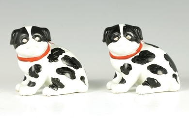 A PAIR OF CONTINENTAL SEATED PUG DOGS with red ribbon