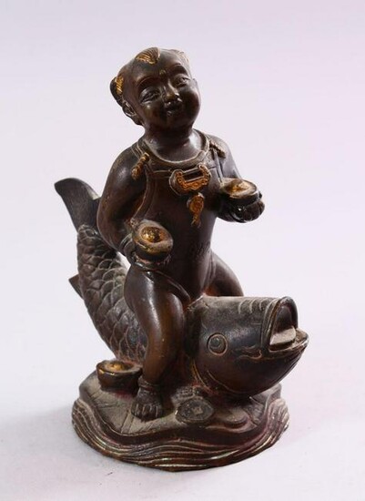 A SMALL CHINESE BRONZE FIGURE OF A BOY SEATED UPON A