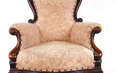 A Victorian walnut framed nursing chair upholstered in a floral...