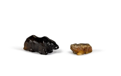 A black stone figure of a recumbent buffalo and a mottled jade figure of a small bear/dog Qing dynasty | 清 黑石臥牛 及 青玉犬 一組兩件