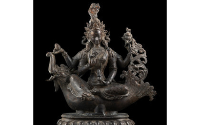 A bronze Avalokiteshvara seated on a mythological beast with lotus base China, 20th century (h. 27 cm.)